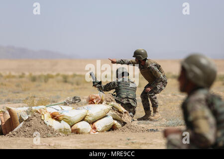 Un instructeur de l'Armée nationale afghane avec le Centre de formation militaire régional Helmand pointe vers une illumination tour après un soldat avec 2e Kandak, 4e Brigade, 215e Corps canadien tire un mortier de 60 mm au Camp Shorabak, Afghanistan, le 10 juin 2017. Les conseillers des marines assigné à la Force sud-ouest sont d'aider les instructeurs enseignent environ 600 militaires tactiques d'infanterie pendant la préparation opérationnelle, un cycle de formation de huit semaines événement visant à créer une force létale et prêt à refuser tout refuge à des insurgés dans la province de Helmand. (U.S. Marine Corps photo par le Sgt. Lucas Hopki Banque D'Images