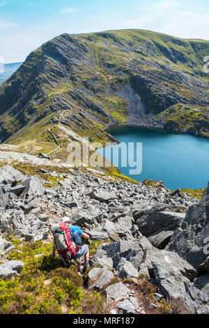 Llyn Hywel et Y Lethr Rhinog de Fach, Pays de Galles, Royaume-Uni. Walker mâle en premier plan Banque D'Images