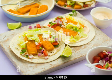 Ouvrir les doigts de poisson tacos tortillas sur mayonnaise et la laitue avec oignon rouge, vert & rouge salade Banque D'Images