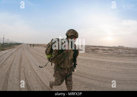 Le Sgt. Calvin Grimes, un soldat avec le 595th bataillon de transport, pousse vers la ligne d'arrivée de la 1ère Commande de soutien (Théâtre) Meilleur guerrier concurrence 10-mile ruck mars au Camp Arifjan, au Koweït le 16 avril, 2017. (US Army Banque D'Images