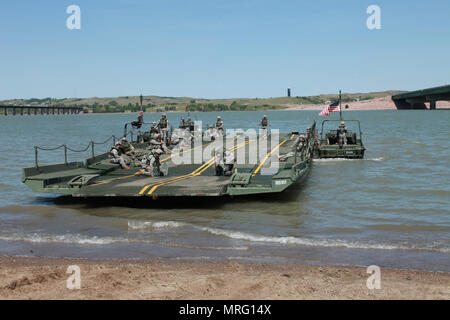 Les soldats de l'Armée américaine à la 200e compagnie du génie, la Garde nationale du Dakota du Sud, se préparer pour charger des véhicules militaires de la Garde nationale du Kansas sur ruban à l'amélioration de la passerelle pendant une opération de passage de la rivière à l'appui de Coyote d'or, Chambellan, S.D., 10 juin 2017. Le Coyote d'or l'exercice est un trois-phase, axée sur des mises en exercice mené dans les Black Hills du Dakota du Sud et le Wyoming, qui permet de se concentrer sur les commandants de mission besoins essentiels concernant la tâche, les tâches et les exercices de guerrier. Banque D'Images