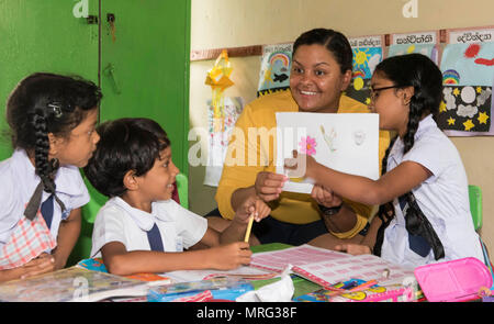 170615-N-OU129-045 Kalutara, Sri Lanka (15 juin 2017) 3ème classe Controlman Feu Julia Robinson, de la classe Ticonderoga croiseur lance-missiles USS Lake Erie (CG 70) interagit avec les élèves de l'école près de Kalutara-Molkawa Kalutara, Sri Lanka, le 15 juin lors d'un événement d'engagement communautaire à l'appui des opérations d'assistance humanitaire à la suite de graves inondations et glissements de terrain qui ont dévasté de nombreuses régions du pays. De fortes pluies récentes portées par une mousson du sud-ouest a déclenché des inondations et des glissements de terrain dans tout le pays, le déplacement de milliers de personnes et causant significa Banque D'Images