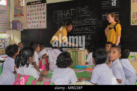 170615-N-OU129-099 Kalutara, Sri Lanka (15 juin 2017) Le lieutenant Mark Rittenhouse et Ensign Natalie Miller de la classe Ticonderoga croiseur lance-missiles USS Lake Erie (CG 70) interagissent avec les élèves de l'école près de Kalutara-Molkawa Kalutara, Sri Lanka, le 15 juin lors d'un événement d'engagement communautaire à l'appui des opérations d'assistance humanitaire à la suite de graves inondations et glissements de terrain qui ont dévasté de nombreuses régions du pays. De fortes pluies récentes portées par une mousson du sud-ouest a déclenché des inondations et des glissements de terrain dans tout le pays, le déplacement de milliers de personnes et causant des sign Banque D'Images