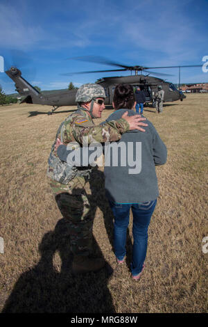 Maître de l'armée américaine le Sgt. Mike Dotson, chef d'équipe avec Joint Force Head Quarters, la Garde nationale du Dakota du Sud parle avec Kim Vanneman membre du Dakota du Sud Conseil d'affaires militaires avant de monter à bord d'un HH-60M Black Hawk de l'évacuation médicale au cours de l'exercice or Coyote au Rapid City, S.D., 15 juin 2017. Le Coyote d'or l'exercice est un trois-phase, axée sur des mises en exercice mené dans les Black Hills du Dakota du Sud et le Wyoming, qui permet de se concentrer sur les commandants de mission besoins essentiels concernant la tâche, les tâches et les exercices de combat guerrier. (U.S. Photo de l'armée par la CPS. Kevin Kim) Banque D'Images