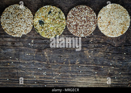 Dessert des collations aux céréales. Aliments diététiques de remise en forme. Kozinaki avec sésame, arachide, tournesol et graines de citrouille, les dates sur la vieille planche de bois rustique. Vegan healt Banque D'Images