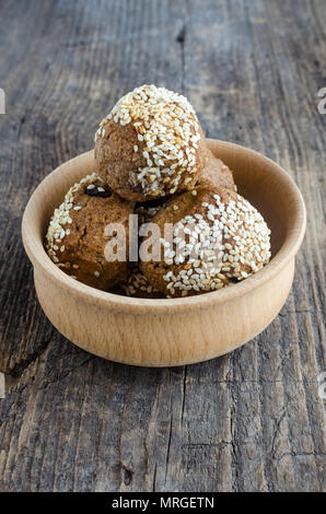 Des collations aux céréales dessert sucré. Aliments diététiques de remise en forme. Banana-biscuits au miel et saupoudré de graines de sésame dans le bol en bois rustique sur l'ancien conseil. Ve Banque D'Images