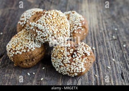 Des collations aux céréales dessert sucré. Aliments diététiques de remise en forme. Banana-biscuits au miel et saupoudré de graines de sésame dans le bol en bois rustique sur l'ancien conseil. Ve Banque D'Images