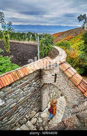 Woman in Hat Tourisme avec sac à dos à l'escalier du monastère Bodbe dans ville Sighnaghi, Géorgie Banque D'Images