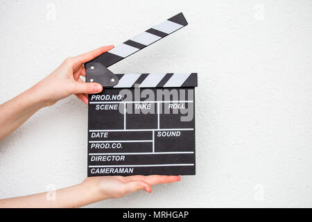 Female hands holding movie clapper isolated on white Banque D'Images