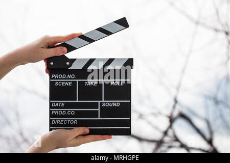 Female hands holding movie clapper isolated on white Banque D'Images