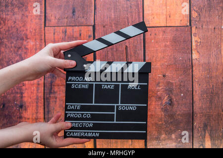 Les plaques à clapet, women's hands et clapper film sur un fond de bois Banque D'Images