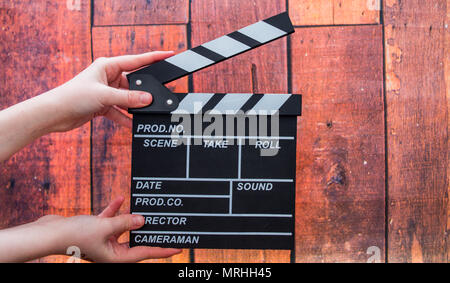 Les plaques à clapet, women's hands et clapper film sur un fond de bois Banque D'Images