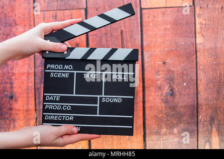Les plaques à clapet, women's hands et clapper film sur un fond de bois Banque D'Images