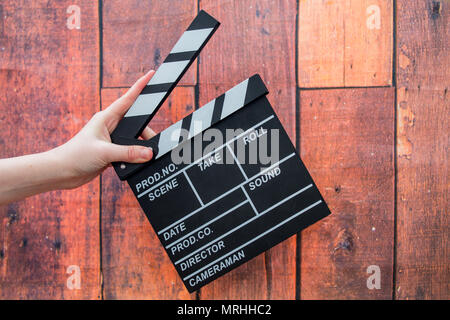 Les plaques à clapet, women's hands et clapper film sur un fond de bois Banque D'Images