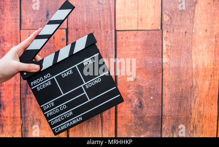 Les plaques à clapet, women's hands et clapper film sur un fond de bois Banque D'Images