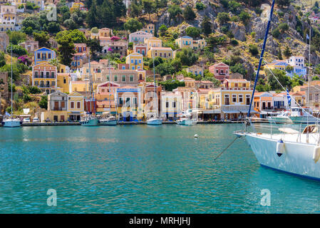 Vue sur baie magnifique avec ses maisons colorées sur la colline de l'île de Symi. Grèce Banque D'Images