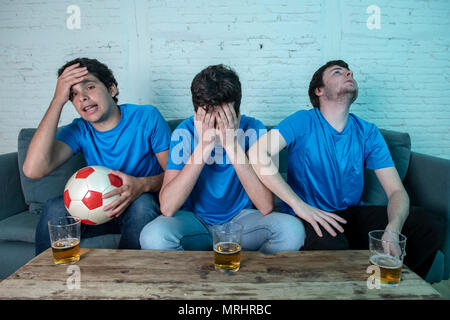 Jeune Groupe de blancs football fans déçus en regardant un match de football sur la table. Banque D'Images