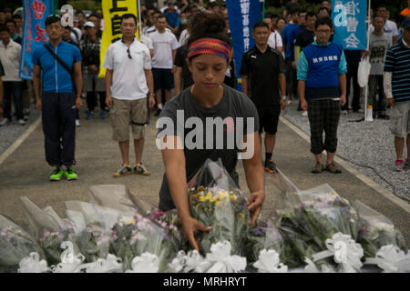 ITOMAN, Japon - Air Force Staff Sgt. Yesenia Benjamin paye son égards en fixant le dernier bouquet de fleurs en l'honneur d'Okinawa Memorial Day le 18 juin au Parc de la paix d'Okinawa la prière, Okinawa, Japon. Benjamin représentait tous de l'American service members qui avaient offert au parc. Des centaines de membres de la communauté militaire locale et se sont réunis pour nettoyer le parc en l'honneur de la guerriers tombés. (Photo par Lance Cpl. Tayler P. Schwamb) Banque D'Images