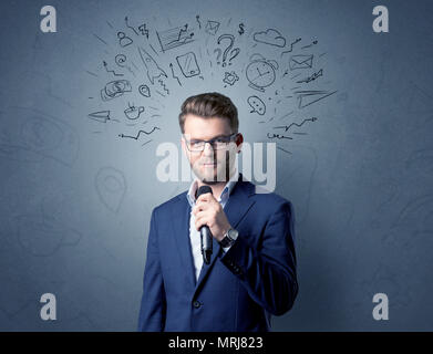 Businessman parlant au micro avec des doodles sur sa tête Banque D'Images