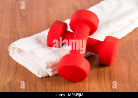 Haltère fitness rouge sur blanc serviette à étage en bois de honte. Concept du sport et des loisirs Banque D'Images