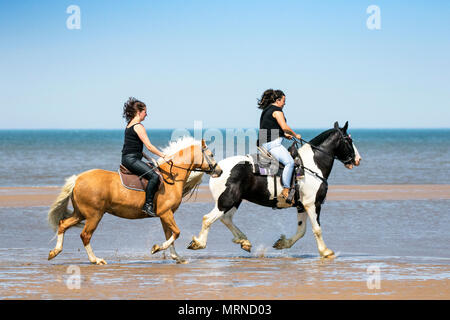 Cavaliers à Southport, Royaume-Uni. 27 mai 2018. Météo britannique. Lors d'un beau séjour ensoleillé en banque dimanche après-midi, Kirsten Hall [L] et Kay Egerton [R] de Blackburn font le tour de leurs chevaux bien-aimés le long de la marée entrante sur les sables dorés de Southport plage de Merseyside. Crédit: Cernan Elias/Alay Live News Banque D'Images