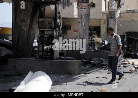 Sanaa, Yémen. 27 mai, 2018. Un homme marche à l'intérieur du quartier général de la compagnie pétrolière d'état après avoir été touchés par les frappes aériennes à Sanaa, Yémen, le 27 mai 2018. Au moins quatre civils ont été tués lors de frappes aériennes de la coalition dirigée par les Saoudiens a frappé le siège de la compagnie pétrolière d'état et les maisons voisines dans la capitale yéménite Sanaa le samedi soir, les fonctionnaires, les résidents et les sauveteurs ont dit. Credit : Mohammed Mohammed/Xinhua/Alamy Live News Banque D'Images