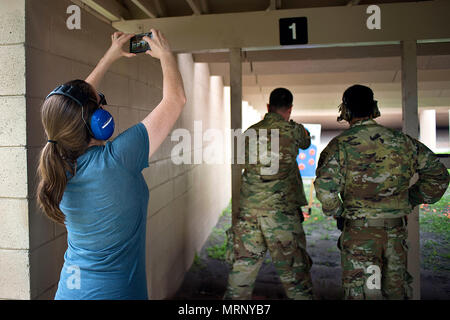 Christie Patterson, l'épouse d'un centre de commandement des opérations spéciales (SOCCENT) états de service, prend une photo de son mari un pistolet de tir pendant la journée conjoint spartiate à la base aérienne MacDill, 13 juin 2017. Au cours de la journée, les conjoints des membres SOCCENT appris comment charger correctement, d'incendie et de décharger une arme de poing. (U.S. Air Force photo par un membre de la 1re classe Caleb Nunez) Banque D'Images