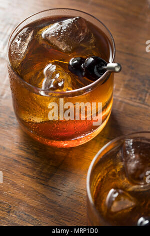 Boozy Manhattan Cocktail sur les rochers avec une garniture de cerises Banque D'Images