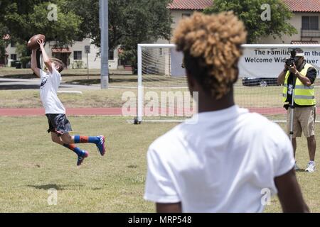 La pratique des enfants passant et attraper des exercices pendant un camp de football des jeunes le 26 juin 2017, at Joint Base San Antonio-Randolph. Le camp de cette année a été le deuxième camp organisé par Terrance Williams, le receveur Dallas Cowboys, à JBSA-Randolph dans trois ans. (U.S. Photo de l'Armée de l'air par la Haute Airman Stormy Archer) Banque D'Images