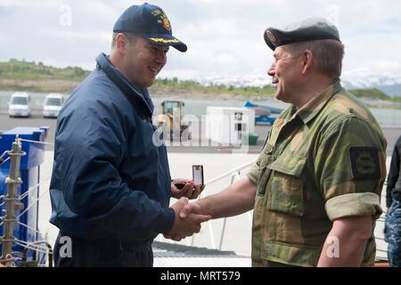 170628-N-FQ994-227 Tromsø, Norvège (28 juin 2017) Le Cmdr. Bryan Gallo, commandant de la classe Arleigh Burke destroyer lance-missiles USS Ross (DDG 71), gauche, échange de cadeaux avec un fonctionnaire de la Home Guard norvégien, District 16, tandis que la location à Tromsø, Norvège, le 28 juin 2017. Ross, l'avant-déployé à Rota, Espagne, mène des opérations navales dans la sixième flotte américaine zone d'opérations à l'appui de la sécurité nationale des États-Unis en Europe et en Afrique. (U.S. Photo par marine Spécialiste de la communication de masse 3e classe Robert S. Price/libérés) Banque D'Images