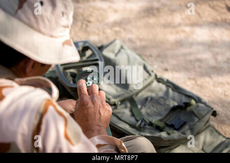 Un soldat de l'armée iraquienne ajuste un détecteur de métal Vallon pendant la formation à la détection des mines Besmaya complexe gamme l'Iraq, le 2 juillet 2017. Cette formation fait partie de la Force opérationnelle interarmées combinée globale - Fonctionnement résoudre inhérent à la mission de renforcer les capacités des partenaires qui se concentre sur la formation et de l'amélioration de la capacité des forces des combats en partenariat avec ISIS. Les GFIM-OIR est la Coalition mondiale pour vaincre ISIS en Iraq et en Syrie. (U.S. Photo de l'armée par le Cpl. Tracy McKithern) Banque D'Images