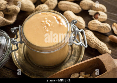 Le beurre d'arachide et de la gelée sur fond de bois. Bon matin petit déjeuner sain. Banque D'Images