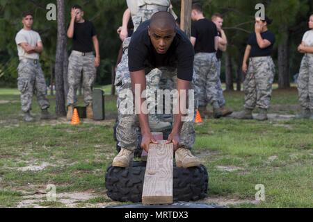 Un ROTC Junior cadet établit une planche pour former un pont de fortune entre deux pneus au cours d'un exercice de renforcement de l'équipe à Hurlburt Field, en Floride, le 26 juin 2017. Plus de 50 cadets JROTC provenant de cinq écoles secondaires locales engagés dans une variété d'équipe et développement des compétences de leadership au cours des exercices de l'École d'été de formation un voyage à Hurlburt Field, Juin 26 - 30. (U.S. Photo de l'Armée de l'air par le sergent. Victor J. Caputo) Banque D'Images