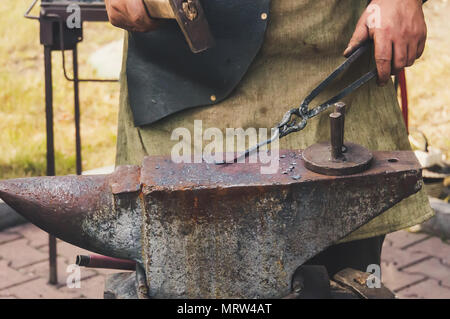 Marteau de forge fer chaud à l'enclume. Marteau à forger de structures métalliques à l'air libre dans une enclume en fonte Banque D'Images