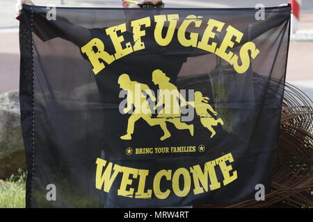 Jockgrim, Allemagne. 26 mai, 2018. Un manifestant tient une bannière qui se lit 'réfugiés bienvenue - Apportez votre famille. Le groupe parlementaire de la droite populiste (AfD alternative pour l'Allemagne) partie de la Rhénanie-Palatinat a célébré le 2ème anniversaire de leur entrée dans la Rhénanie, le Parlement dans l'élection d'état de 2016 dans le Palatinat du Sud ville de Jockgrim. Une contre-manifestation était organisée par plusieurs groupes à l'extérieur de la salle. Crédit : Michael Debets Pacifique/Pres/Alamy Live News Banque D'Images