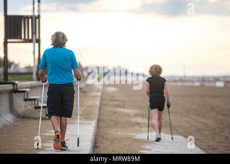 Senior couple nordic waling sur la plage. Banque D'Images