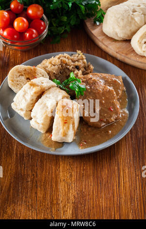 Carré de porc en sauce avec des boulettes de pain et la choucroute. La cuisine tchèque Banque D'Images