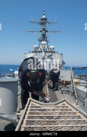 170630-N-ZE250-017 MER MÉDITERRANÉE (30 juin 2017) - Matelot Recruter Brinio Urena procède à l'entretien de la préservation de la chaîne d'ancre à bord de la classe Arleigh Burke destroyer lance-missiles USS Carney (DDG 64) dans la mer Méditerranée le 30 juin 2017. Carney, l'avant-déployé à Rota, Espagne, effectue actuellement sa troisième patrouille dans la sixième flotte américaine zone d'opérations à l'appui de la sécurité nationale des États-Unis en Europe. (U.S. Photo par marine Spécialiste de la communication de masse de la classe 3ème Weston Jones/libérés) Banque D'Images