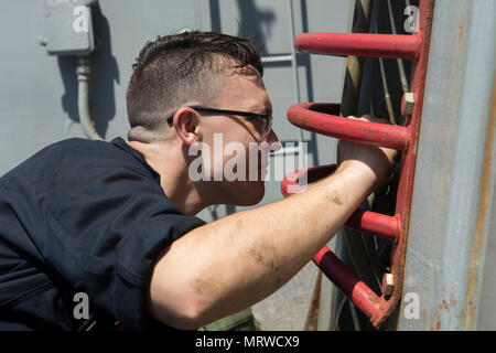 170630-N-ZE250-043 MER MÉDITERRANÉE (30 juin 2017) - Pompier Jakob Moore procède à l'entretien sur la vitre coulissante padeye à bord de la classe Arleigh Burke destroyer lance-missiles USS Carney (DDG 64) dans la mer Méditerranée le 30 juin 2017. Carney, l'avant-déployé à Rota, Espagne, effectue actuellement sa troisième patrouille dans la sixième flotte américaine zone d'opérations à l'appui de la sécurité nationale des États-Unis en Europe. (U.S. Photo par marine Spécialiste de la communication de masse de la classe 3ème Weston Jones/libérés) Banque D'Images