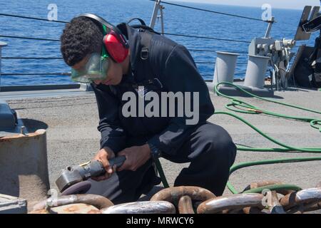 170630-N-ZE250-017 MER MÉDITERRANÉE (30 juin 2017) - Matelot Recruter Brinio Urena procède à l'entretien de la préservation de la chaîne d'ancre à bord de la classe Arleigh Burke destroyer lance-missiles USS Carney (DDG 64) dans la mer Méditerranée le 30 juin 2017. Carney, l'avant-déployé à Rota, Espagne, effectue actuellement sa troisième patrouille dans la sixième flotte américaine zone d'opérations à l'appui de la sécurité nationale des États-Unis en Europe. (U.S. Photo par marine Spécialiste de la communication de masse de la classe 3ème Weston Jones/libérés) Banque D'Images