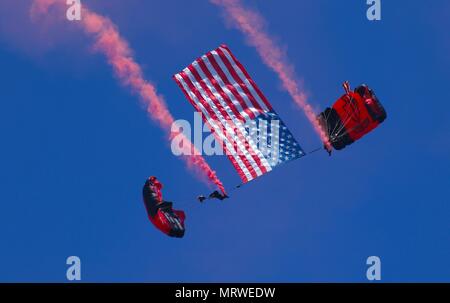 SCHOFIELD BARRACKS, New York -membres de l'équipe de l'US Army Special Operations Command, l'équipe de démonstration de parachutisme de poignards noire, qui a sauté d'un CH-47 Chinook 4 juillet 2017, glisse vers le bas dans la foule portant un drapeau américain pour la célébration du Jour de l'indépendance à Schofield Barracks. Les poignards noire effectuer des sauts haute altitude ouverture basse à l'appui d'opérations spéciales de recrutement et de relations communautaires. (U.S. Photo de l'armée par le Sgt. Ian Ives, 25e Brigade de soutien Public Affairs /relâché). Banque D'Images