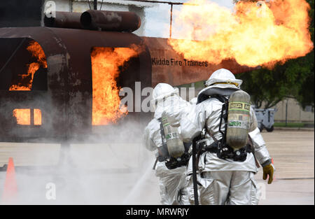 Les pompiers de Keesler utiliser un tuyau pour éteindre une formation de pompier aide au cours d'un exercice de tir réel sur la piste le 6 juin 2017, sur la base aérienne de Keesler, mademoiselle l'incendie, le ministère de Keesler Gulfport CRTC Fire Department et le service d'incendie de Stennis Space Center sont tous nécessaires à la pratique service de Sauvetage et lutte contre les incendies pour répondre à une exigence de formation semi-annuel. (U.S. Air Force photo par Kemberly Groue) Banque D'Images