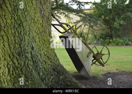 Brouette victorien antique appuyé contre un CedarTree, Canons Ashby, Northamptonshire Banque D'Images