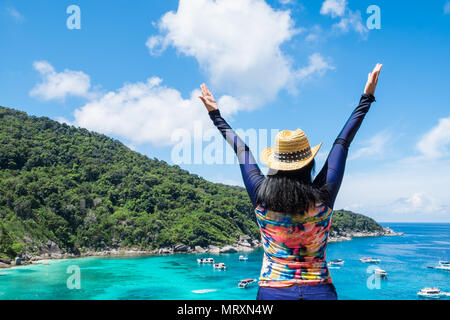 Traveler asian woman with colorful maillot de bras levés au ciel en haut de montagne avec vue sur l'océan bleu et la vitesse bateau en mer vacances d'été,trav Banque D'Images