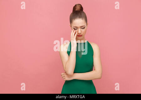 Portrait de femme avec tristesse malheureux cheveux recueillis pleurer. Expression de l'émotion et les sentiments concept. Studio shot, isolé sur fond rose Banque D'Images