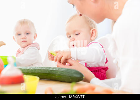 Cute baby girl manger sain aliments solides dans une garderie moderne Banque D'Images