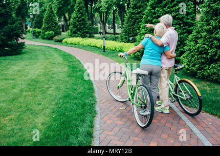 Couple avec leurs vélos dans le parc, vue arrière Banque D'Images