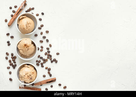 Glace au café sur fond blanc, vue du dessus. Café crème glace gelato congelé avec des grains de café et la cannelle - dessert d'été en bonne santé. Banque D'Images