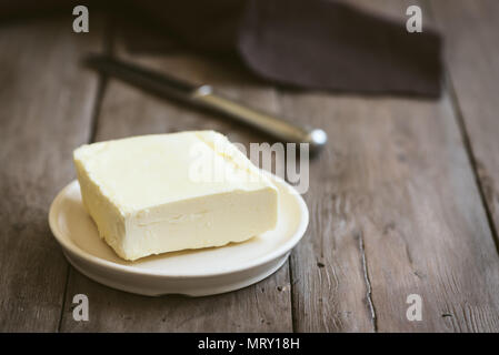 Beurre sur fond de bois foncé, copiez l'espace. Produits laitiers de ferme - beurre. Banque D'Images