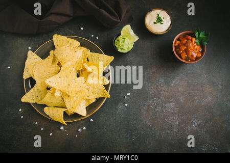 Nachos chips et diverses sauces dip, copiez l'espace. Maïs tortilla chips nachos avec de la salsa, de fromage fondu et de guacamole mexicain, des collations. Banque D'Images